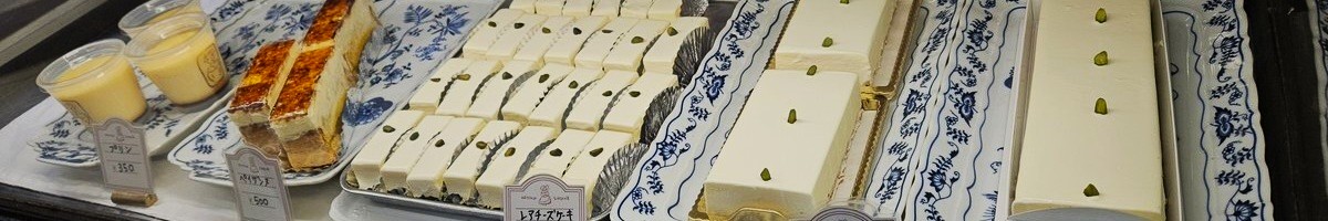 Assorted desserts in a case, including cheesecakes of many sizes and other cakes.