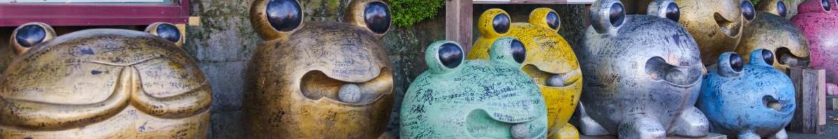 Line of metal frog statues in different poses, of slightly different sizes and colors.