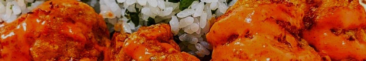 Close-up image of fried chicken pieces covered with orange sauce, paired with rice on the side.