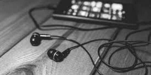 black and white image of headphones attached to a small smartphone showing a music player screen