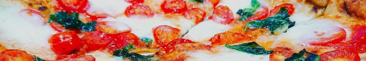 Close-up photo of pizza with cheese, cherry tomatoes, and basil leaves as toppings.